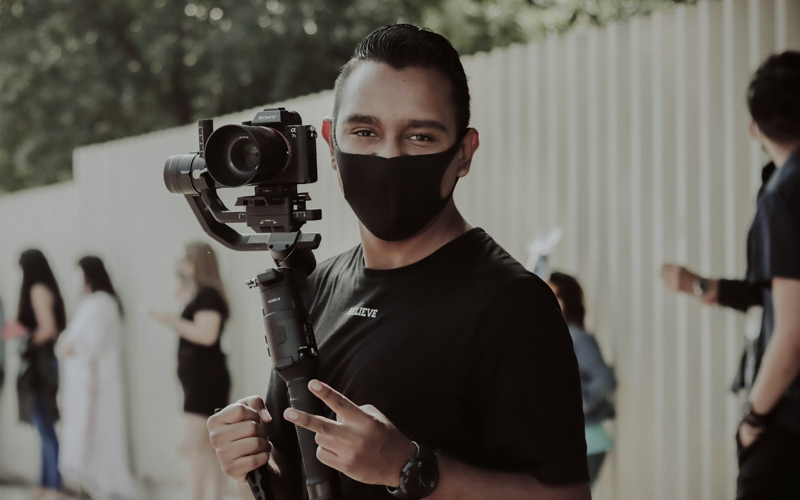 man in black crew neck shirt holding black dslr camera